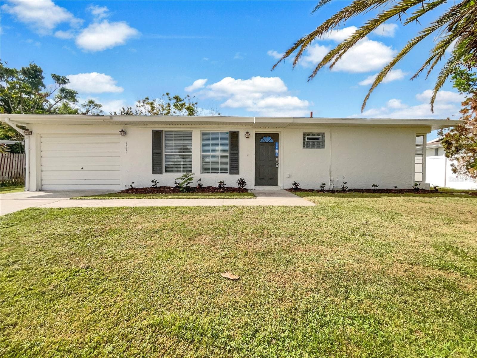 Front exterior of a single-family home with fresh neutral paint and landscaped lot.