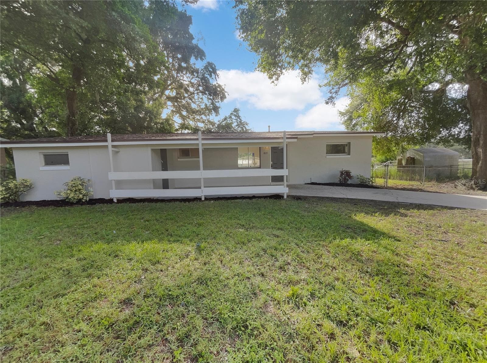 Exterior view of a single-family home with fresh paint and a patio area.