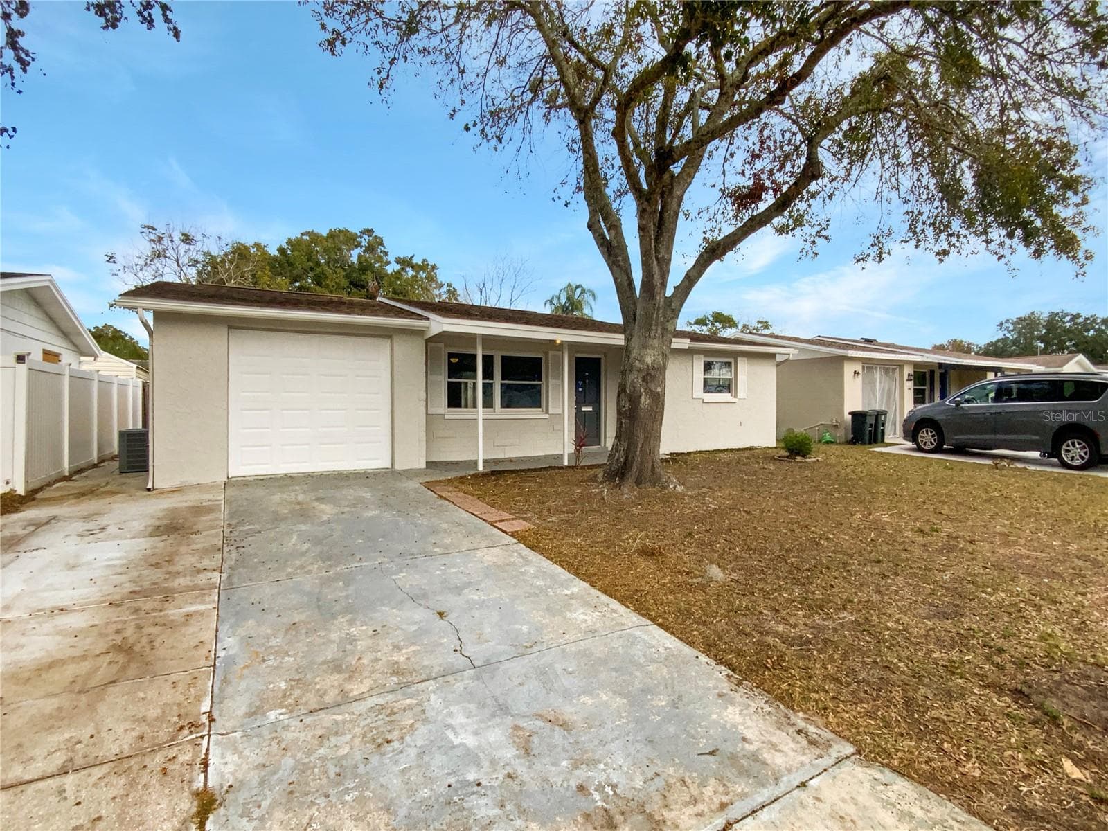 Front exterior of a single-family home with fresh paint in Holiday, FL