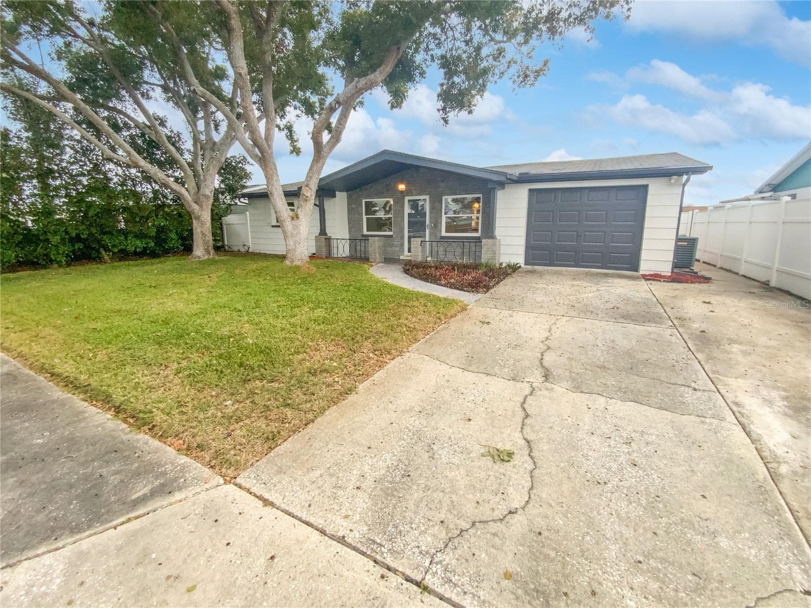 Front exterior of a two-bedroom single-family home with fresh paint in Holiday, FL.