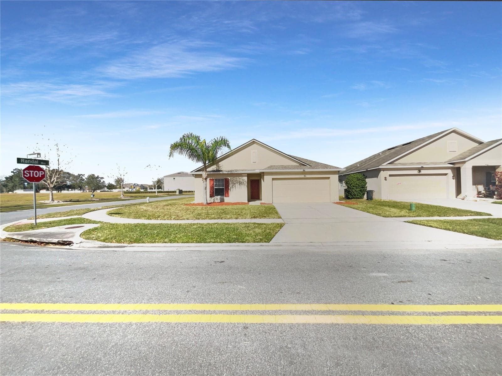 Front exterior of a single-family home with neutral paint and landscaping in Kissimmee, FL.