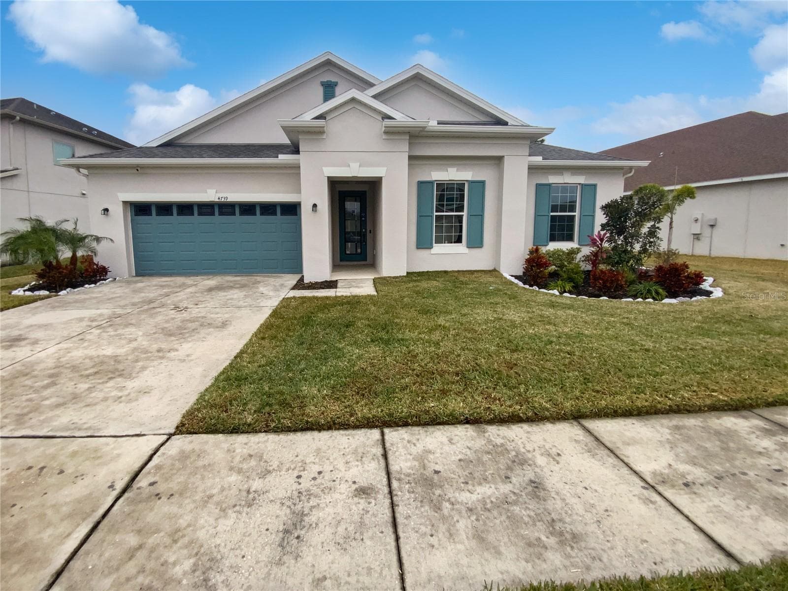 Front exterior of a two-story Wesley Chapel home with fresh paint and manicured landscaping.