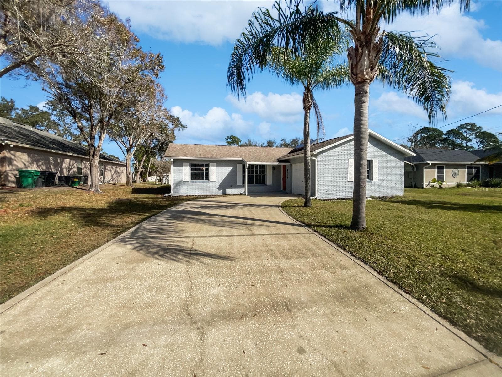 Front exterior of a single-family home on a tree-lined lot in DeBary, Florida.